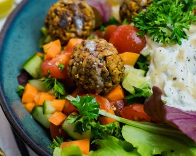Bunte Bowl mit Salat, Couscous, Hackbällchen und Tahin-Sauce
