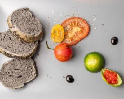 Mozzarella im Basilikummantel mit Tomatenperlen und schwarzem Pizzabrot