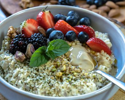 Hirseporridge mit Nüssen, Nussmus und frischen Beeren 