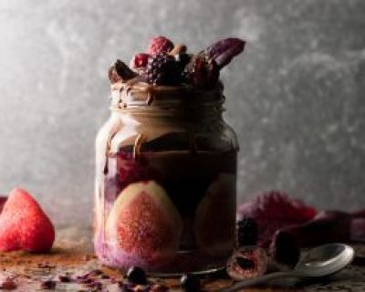 Aufgehübschtes Glas mit Beeren-Chiapudding, Schoko-Nicecream und Früchten